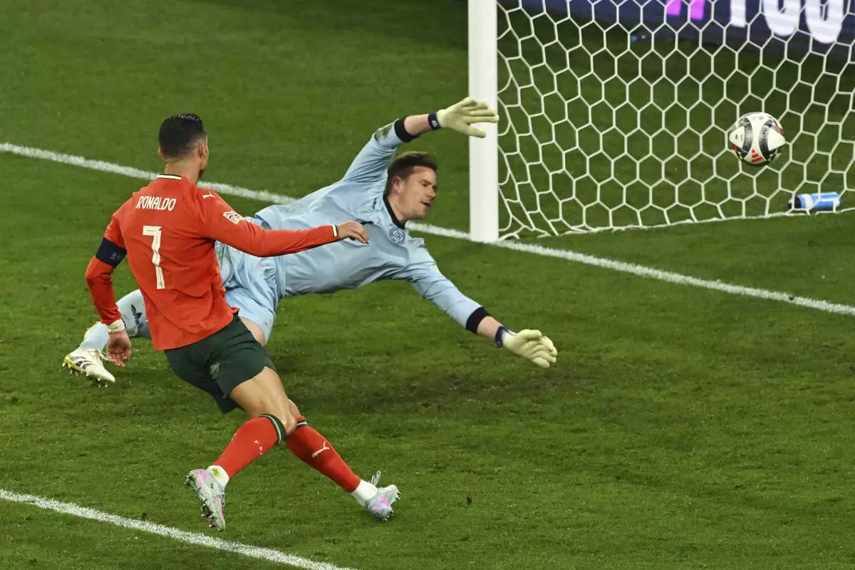 Portugal's Cristiano Ronaldo, left, scores his side's second goal during the Nations League semifinal soccer match between Portugal and Germany in Munich, Germany, Wednesday, June 4, 2025. (Peter Kneffel/dpa via AP)