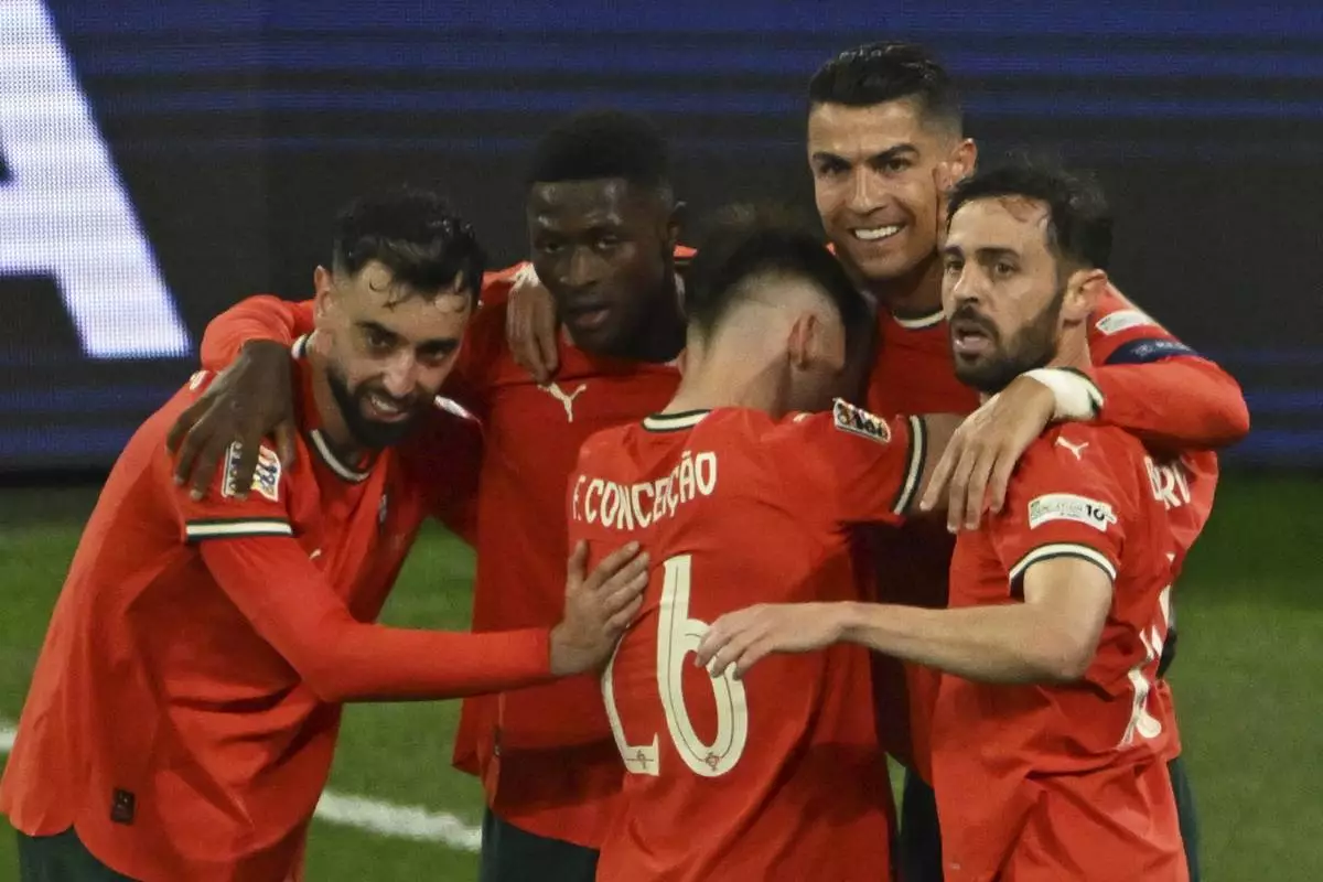 Portugal's Cristiano Ronaldo, second right, celebrates after scoring his side's second goal during the Nations League semifinal soccer match between Portugal and Germany in Munich, Germany, Wednesday, June 4, 2025. (Peter Kneffel/dpa via AP)