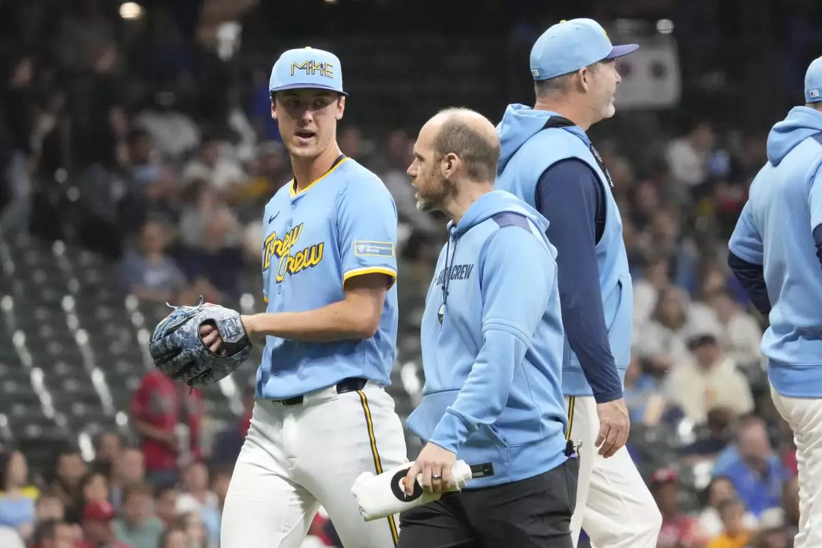 Milwaukee Brewers pitcher Jacob Misiorowski, left, walks off the field with head athletic trainer Brad Epstein, second from left, during the sixth inning of a baseball game against the St. Louis Cardinals, Thursday, June 12, 2025, in Milwaukee. (AP Photo/Kayla Wolf)