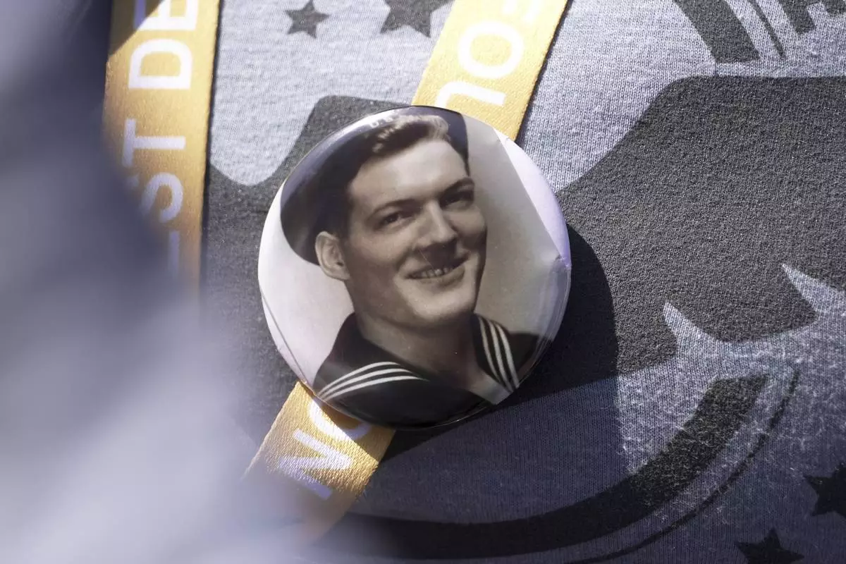 A black and white photo that Kara Houser, the granddaughter of a World War II veteran, pinned to her chest during a visit on Monday, June 2, 2025 in Colleville-sur-Mer, to the Normandy American Cemetery shows Fred Mitchell Shafer, who Houser said served aboard one of the landing craft that deposited American soldiers on Omaha Beach during the June 6, 1944, D-Day invasion of Nazi-occupied France (AP Photo/John Leicester)