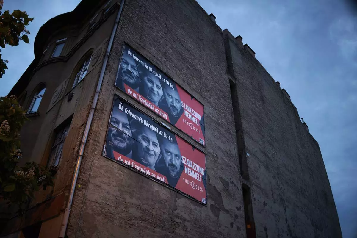 A Hungarian government billboard, opposing Ukraine's EU membership, showing, from left, the leader of the European People's Party Manfred Weber, European Commission President Ursula von der Leyen and Ukrainian President Volodymyr Zelenskyy which reads "They would bring Ukraine into the EU, but we would pay the price! Let's vote no!", is placed on a building In Budapest, Hungary, Monday, June 16, 2025. (AP Photo/Bela Szandelszky)