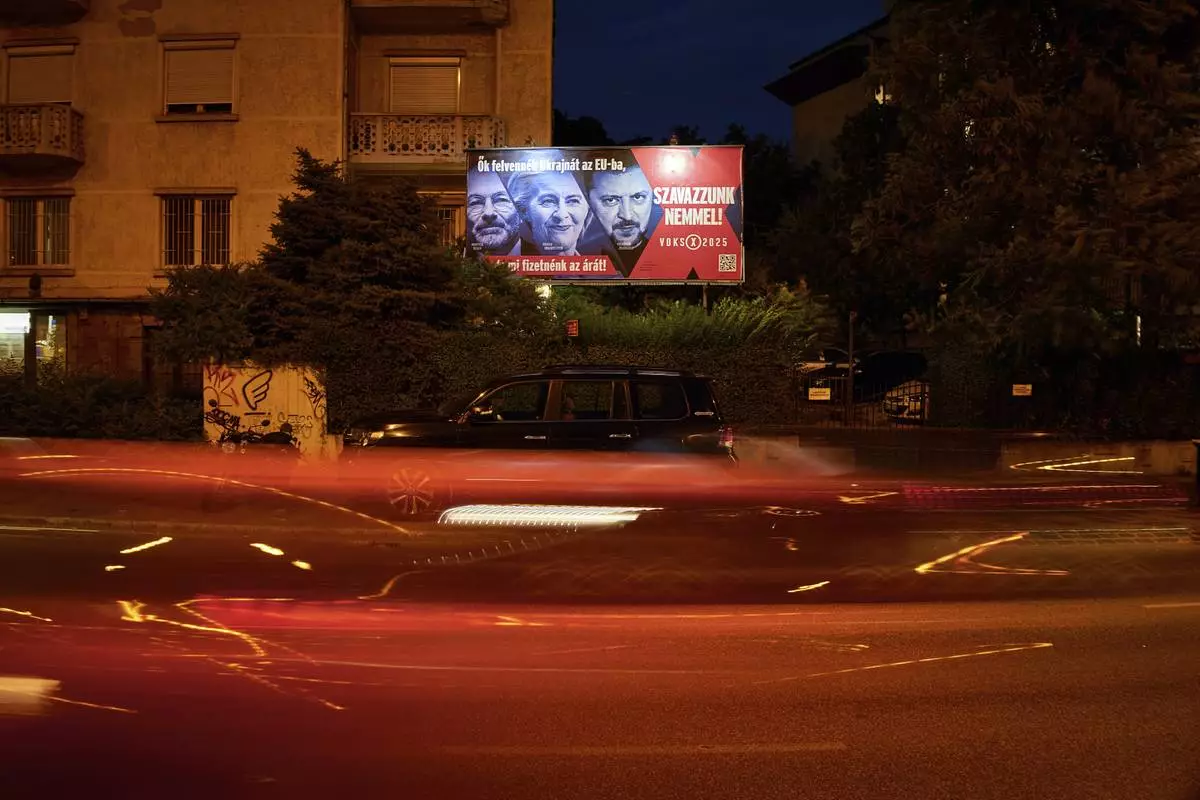 A Hungarian government billboard, opposing Ukraine's EU membership, showing, from left, the leader of the European People's Party Manfred Weber, European Commission President Ursula von der Leyen and Ukrainian President Volodymyr Zelenskyy which reads "They would bring Ukraine into the EU, but we would pay the price! Let's vote no!", is placed on a street In Budapest, Hungary, Monday, June 16, 2025. (AP Photo/Bela Szandelszky)