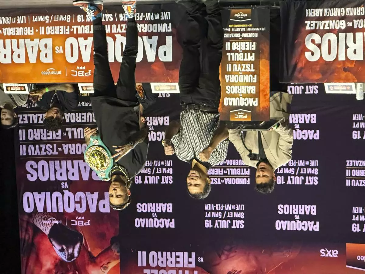 Manny Pacquiao, center, and WBC welterweight champion Mario Barrios pose at a news conference in Los Angeles on Tuesday, June 3, 2025. (AP Photo/Greg Beacham)