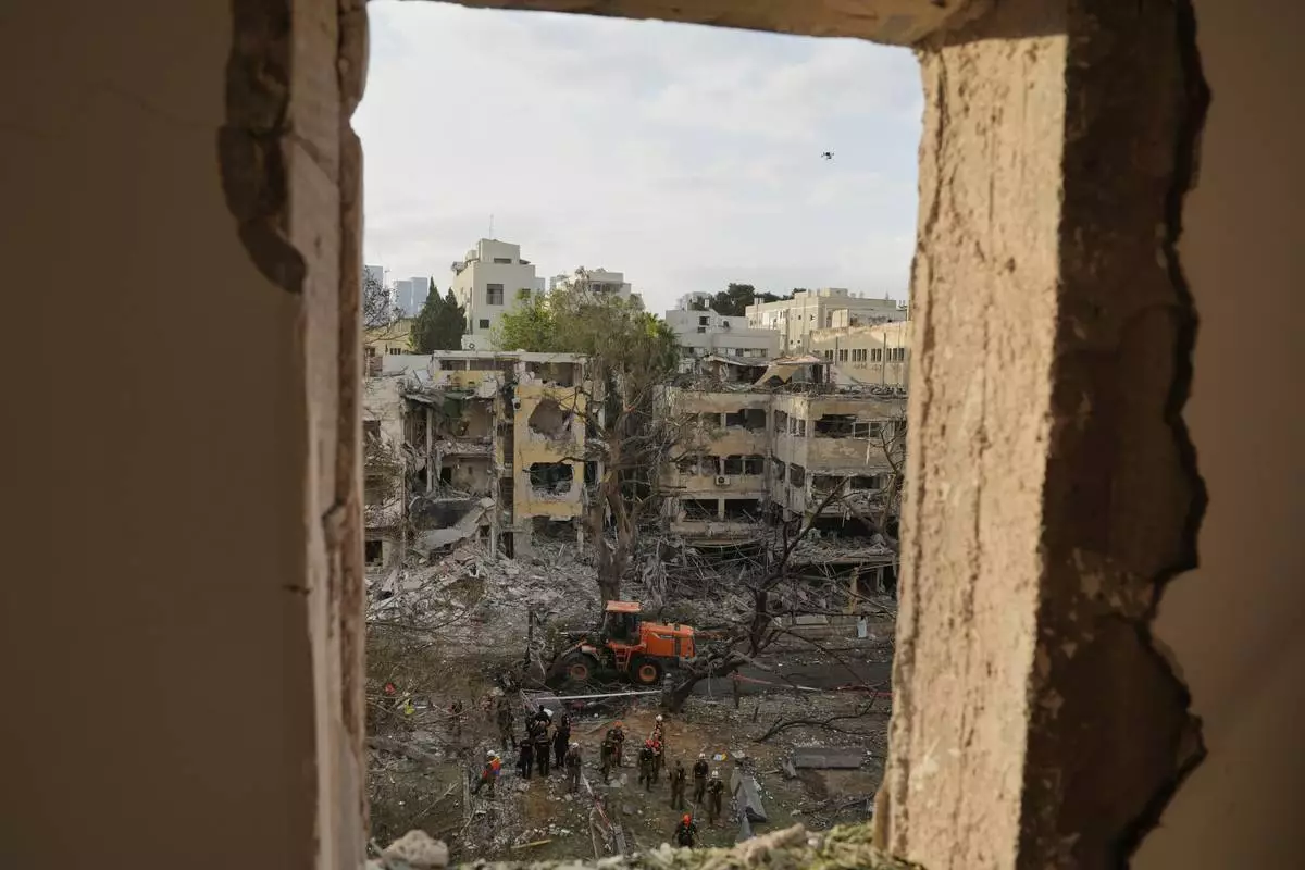 Rescue team work at the site where a missile launched from Iran struck Tel Aviv, Israel, Monday, June 16, 2025. (AP Photo/Baz Ratner)
