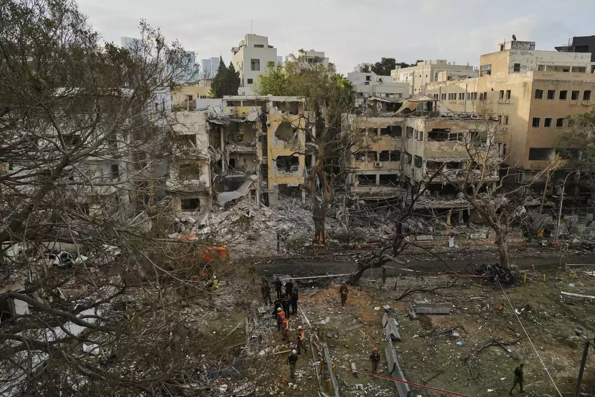 Rescue team work at the site where a missile launched from Iran struck Tel Aviv, Israel, Monday, June 16, 2025. (AP Photo/Baz Ratner)