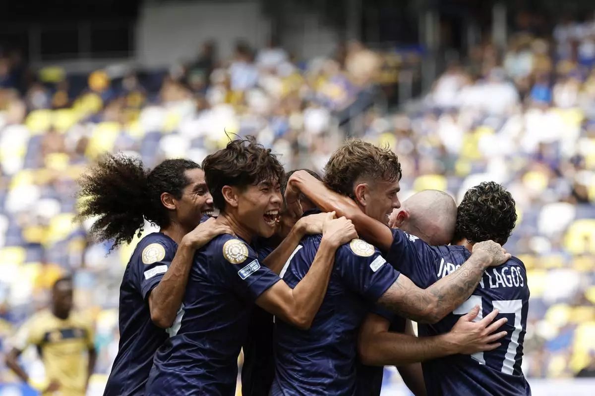 Auckland City's Christian Gray, second right, celebrates after scoring his side's opening goal with teammates during the Club World Cup Group C soccer match between Auckland City and Boca Juniors in Nashville, Tenn., Tuesday, June 24, 2025. (AP Photo/Johnnie Izquierdo)