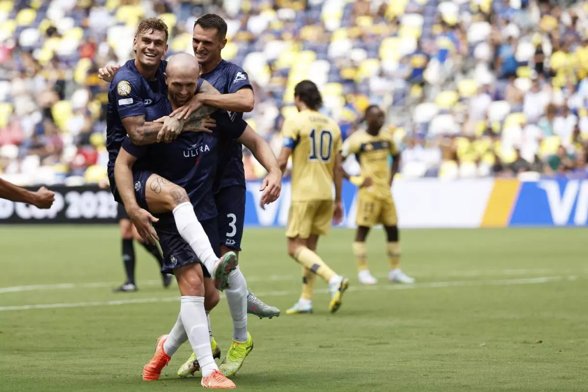 Auckland City's Christian Gray, center, celebrates after scoring his side's opening goal with teammates during the Club World Cup Group C soccer match between Auckland City and Boca Juniors in Nashville, Tenn., Tuesday, June 24, 2025. (AP Photo/Johnnie Izquierdo)