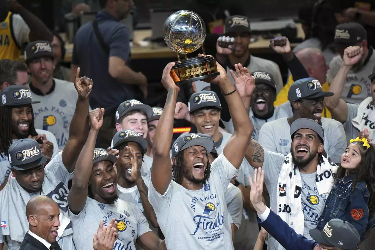 Indiana Pacers center Myles Turner holds the trophy as players celebrate after winning Game 6 of the Eastern Conference finals of the NBA basketball playoffs against the New York Knicks in Indianapolis, Saturday, May 31, 2025. (AP Photo/AJ Mast)