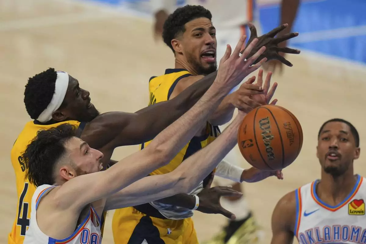 Indiana Pacers forward Pascal Siakam, Oklahoma City Thunder forward Chet Holmgren, left, and Indiana Pacers guard Tyrese Haliburton, center, battle for the rebound during the second half of Game 5 of the NBA Finals basketball series, Monday, June 16, 2025, in Oklahoma City. (AP Photo/Nate Billings)