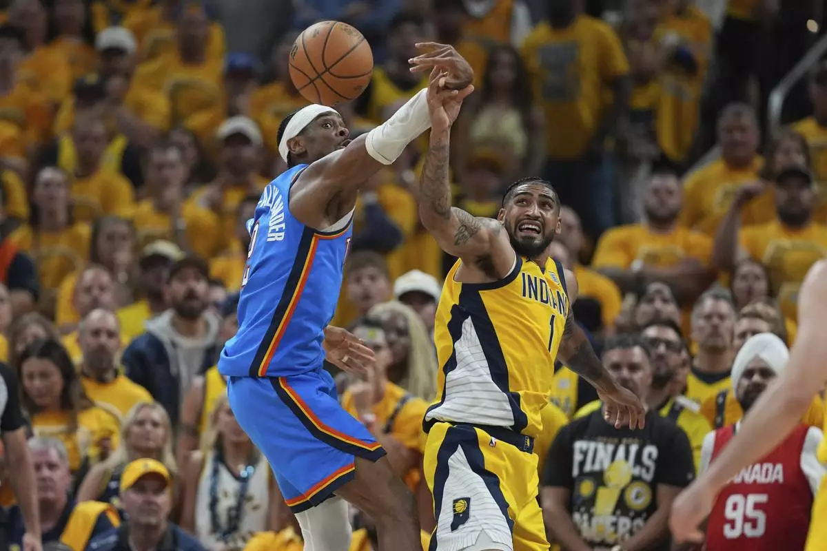 Oklahoma City Thunder guard Shai Gilgeous-Alexander (2) and Indiana Pacers forward Obi Toppin (1) battle for the ball during the second half of Game 4 of the NBA Finals basketball series, Friday, June 13, 2025, in Indianapolis. (AP Photo/Michael Conroy)