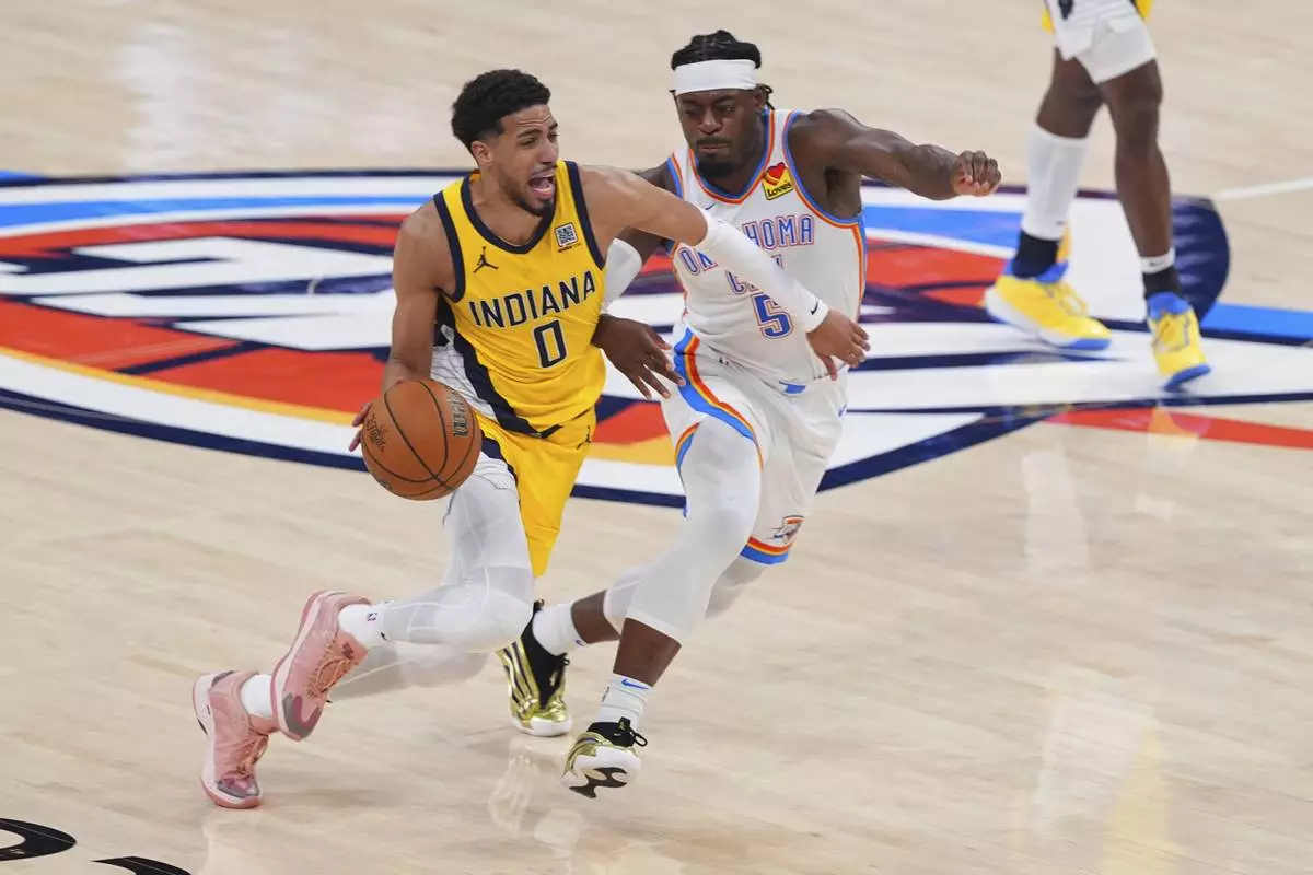 Indiana Pacers guard Tyrese Haliburton (0) drives past Oklahoma City Thunder guard Luguentz Dort (5) during the second half of Game 5 of the NBA Finals basketball series, Monday, June 16, 2025, in Oklahoma City. (AP Photo/Kyle Phillips)