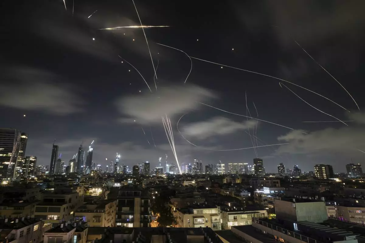 The Israeli Iron Dome air defense system fires to intercept missiles during an Iranian attack over Tel Aviv, Israel, early Wednesday, June 18, 2025. (AP Photo/Leo Correa)