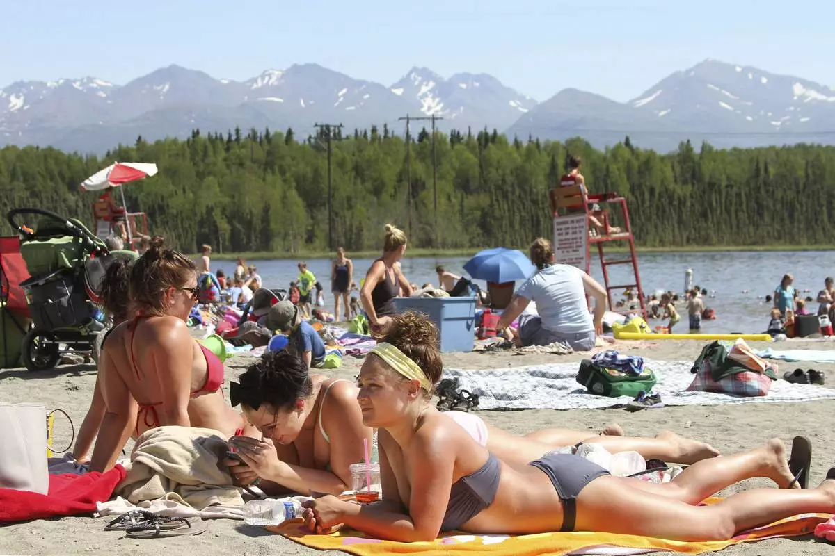FILE - People sunbathe at Goose Lake in Anchorage, Alaska., June 17, 2013. (AP Photo/Mark Thiessen, File)