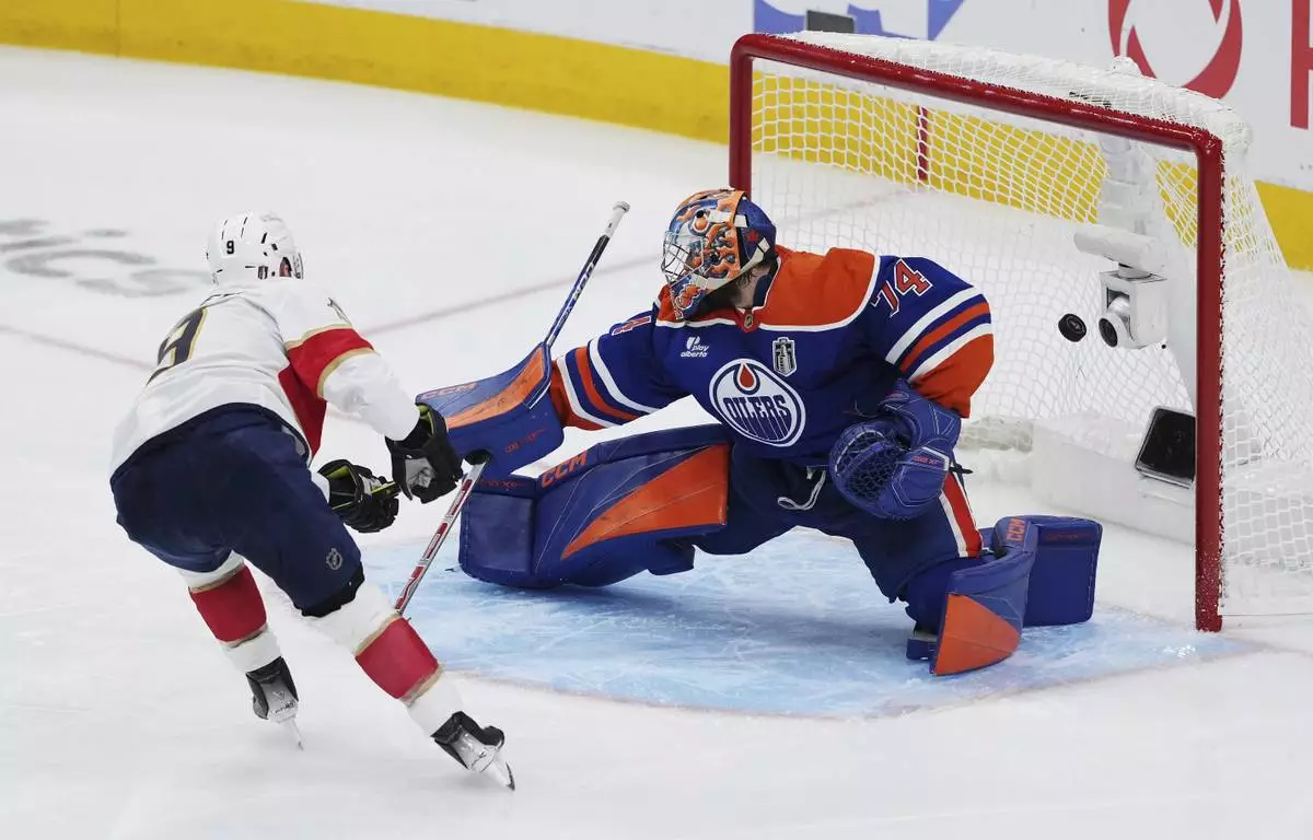 Florida Panthers' Sam Bennett (9) scores on Edmonton Oilers goalie Stuart Skinner (74) during the second period in Game 1 of the NHL hockey Stanley Cup final series in Edmonton, Alberta, Wednesday, June 4, 2025. (Darryl Dyck/The Canadian Press via AP)