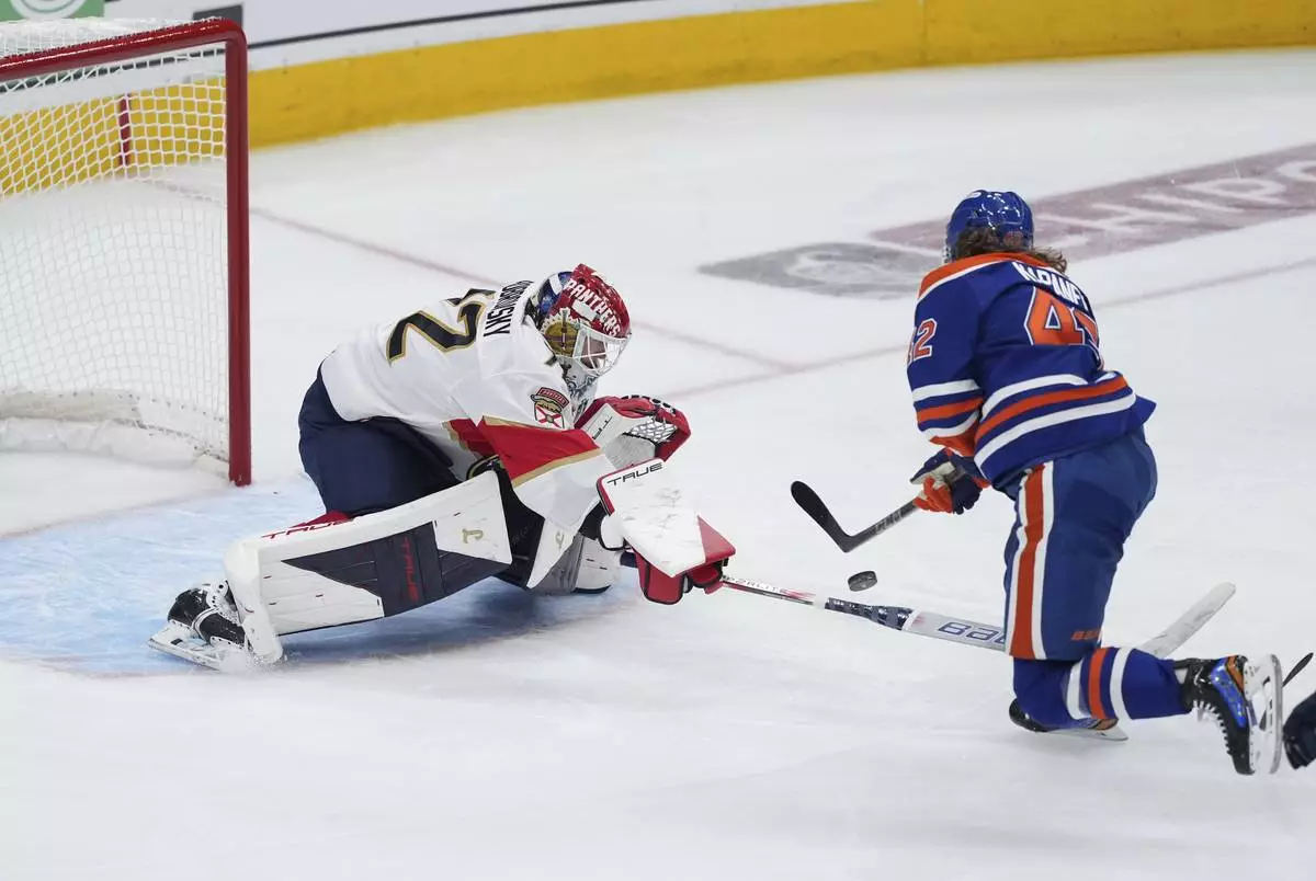 Edmonton Oilers' Kasperi Kapanen, right, puts a shot wide of the net as Florida Panthers goalie Sergei Bobrovsky poke-checks him during the first overtime period in Game 1 of the NHL Stanley Cup Final, in Edmonton, Alberta, on Wednesday, June 4, 2025. (Darryl Dyck/The Canadian Press via AP)