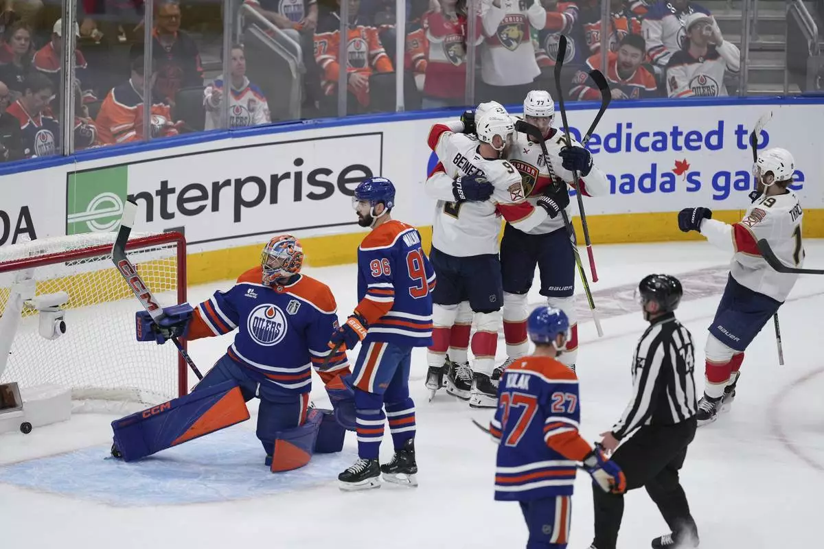 Florida Panthers' Sam Bennett (9), Carter Verhaeghe (23), Niko Mikkola (77) and Matthew Tkachuk (19) celebrate a goal against Edmonton Oilers goalie Stuart Skinner (74) as Jake Walman (96) and Brett Kulak (27) look on during the first period in Game 1 of the NHL Stanley Cup Final, in Edmonton, Alberta, on Wednesday, June 4, 2025. (Darryl Dyck/The Canadian Press via AP)