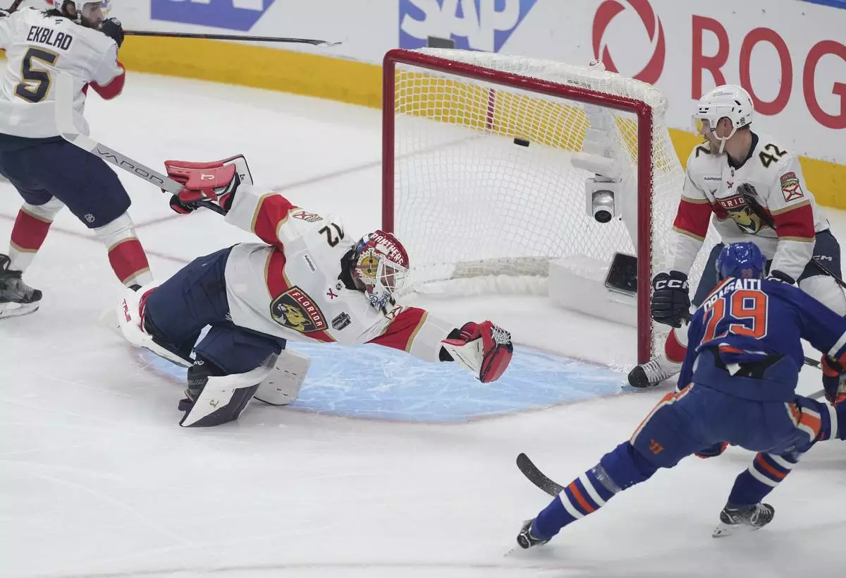Edmonton Oilers' Leon Draisaitl (29) scores against Florida Panthers goalie Sergei Bobrovsky (72) as Gustav Forsling (42) and Aaron Ekblad (5) watch during the first period in Game 1 of the NHL hockey Stanley Cup final series in Edmonton, Alberta, Wednesday, June 4, 2025. (Darryl Dyck/The Canadian Press via AP)