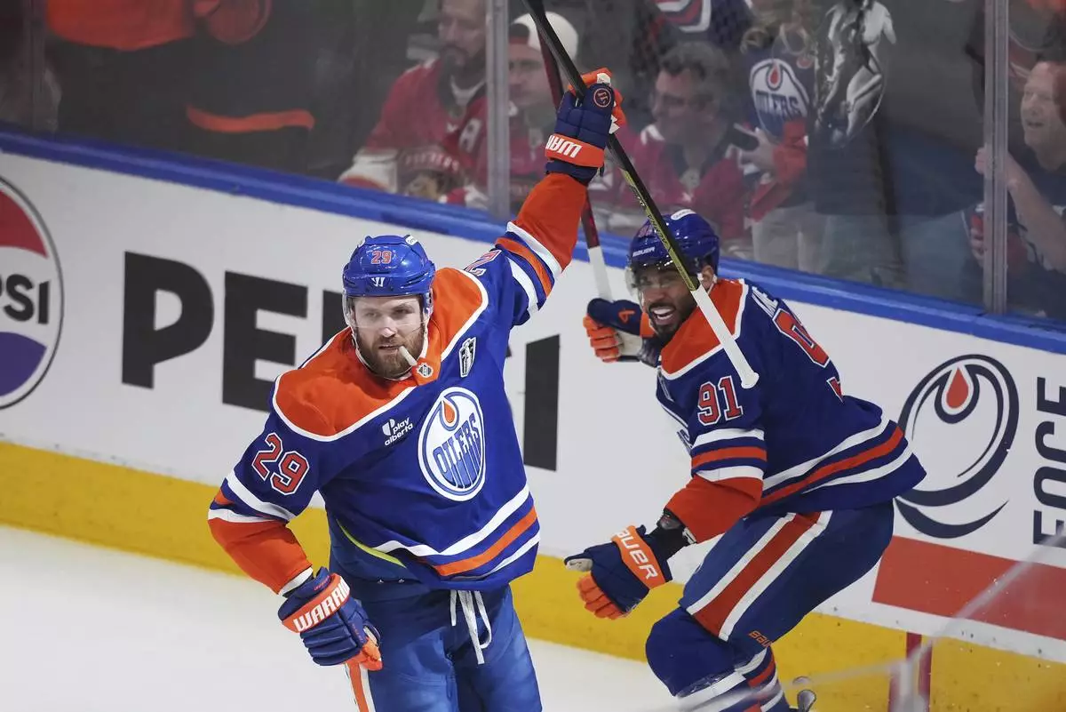 Edmonton Oilers' Leon Draisaitl, left, celebrates his goal against the Florida Panthers with Evander Kane during the first period in Game 1 of the NHL hockey Stanley Cup Finals, in Edmonton, Alberta, Wednesday, June 4, 2025. (Darryl Dyck/The Canadian Press via AP)