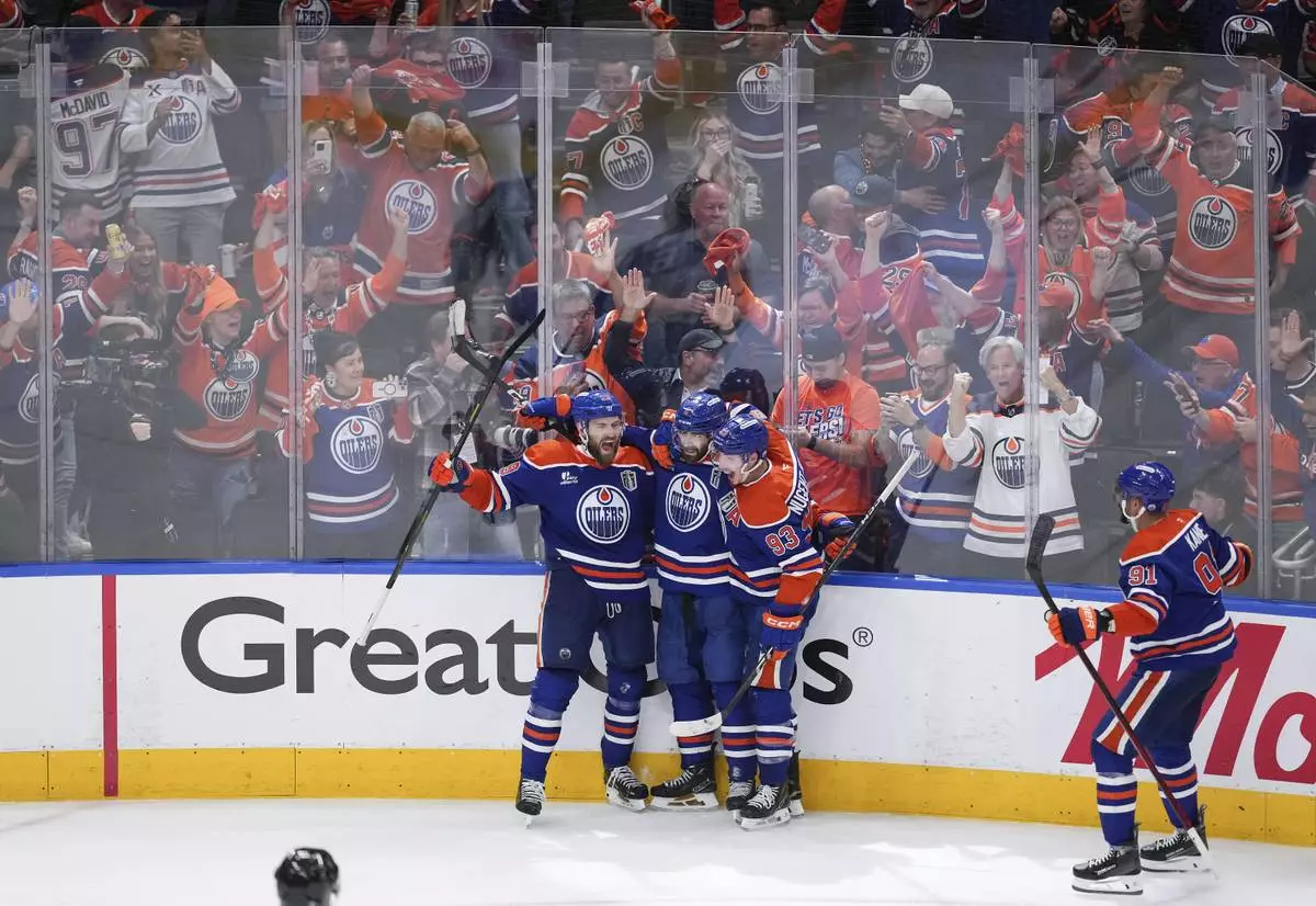 Edmonton Oilers' Leon Draisaitl, from left to right, Evan Bouchard, Ryan Nugent-Hopkins and Evander Kane celebrate Draisaitl's winning goal during the first overtime period in Game 1 of the NHL Stanley Cup Final against the Florida Panthers, in Edmonton, Alberta, on Wednesday, June 4, 2025. (Darryl Dyck/The Canadian Press via AP)