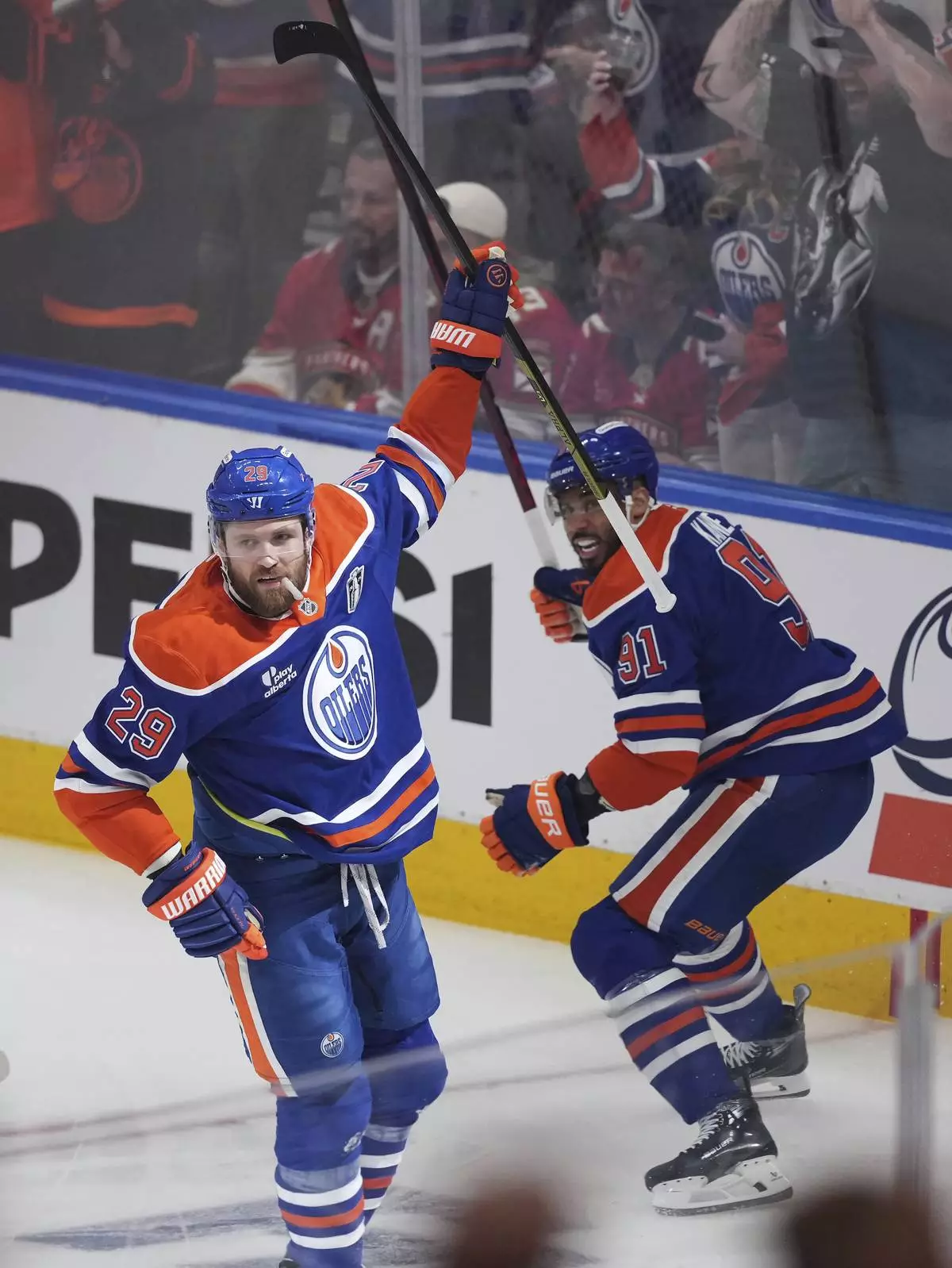 Edmonton Oilers' Leon Draisaitl, left, celebrates his goal against the Florida Panthers with Evander Kane, right, during the first period in Game 1 of the NHL hockey Stanley Cup Finals, in Edmonton, Alberta, on Wednesday, June 4, 2025. (Darryl Dyck/The Canadian Press via AP)