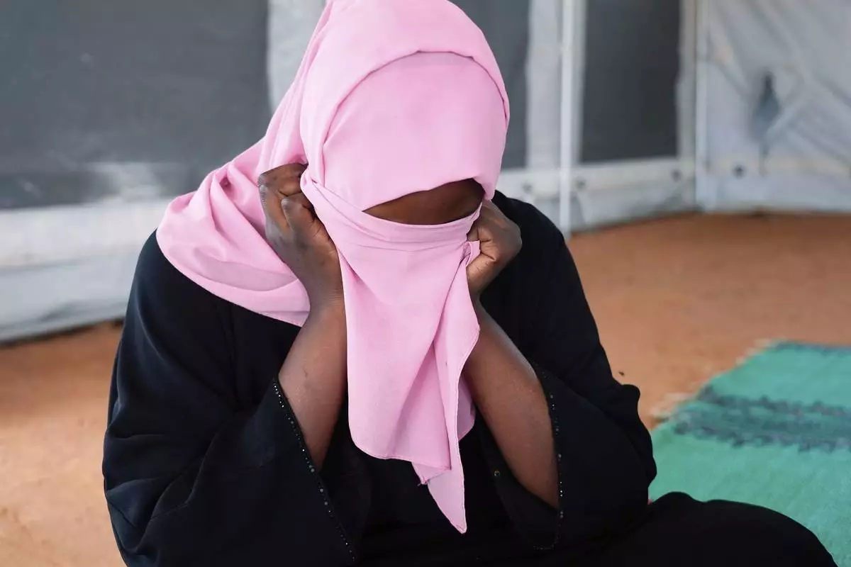 FILE - A woman who fled war in Sudan and requested anonymity because she feared retribution after reporting sexual exploitation, sits in a refugee camp in Adre, Chad, Oct. 3, 2024. (AP Photo/Sam Mednick, File)