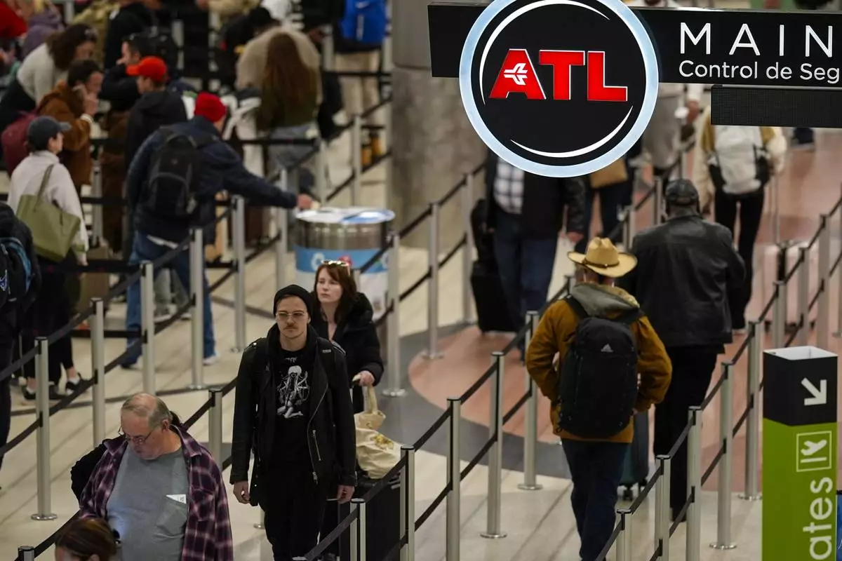 FILE - Travelers move through Hartsfield-Jackson Atlanta International Airport, Friday, Dec. 20, 2024, in Atlanta. (AP Photo/Mike Stewart, File)