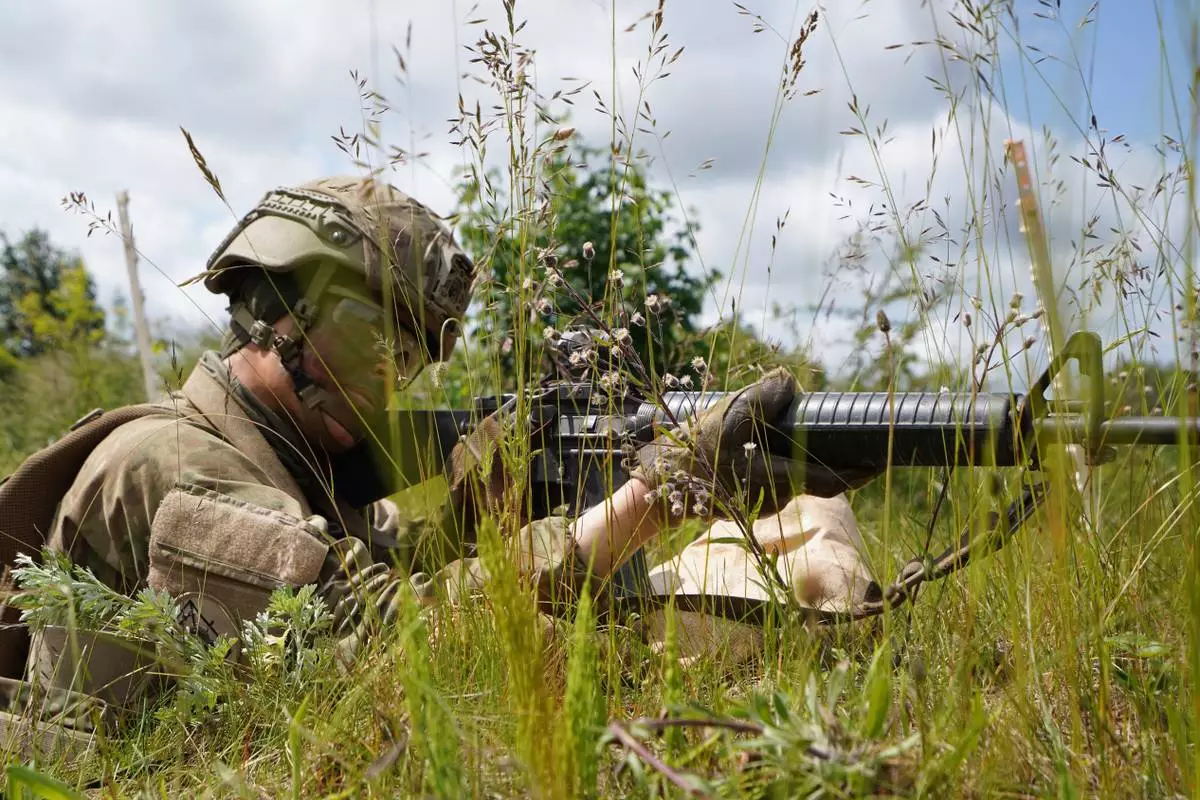CORRECTS THE NAME OF PERSON'S ROLE A young servecemember aims his rifle during final exercises at a training area close to Royal Danish Army’s barracks in Hovelte, 25 kilometres north of Copenhagen, Denmark, Wednesday, June 11, 2025. (AP Photo/James Brooks)
