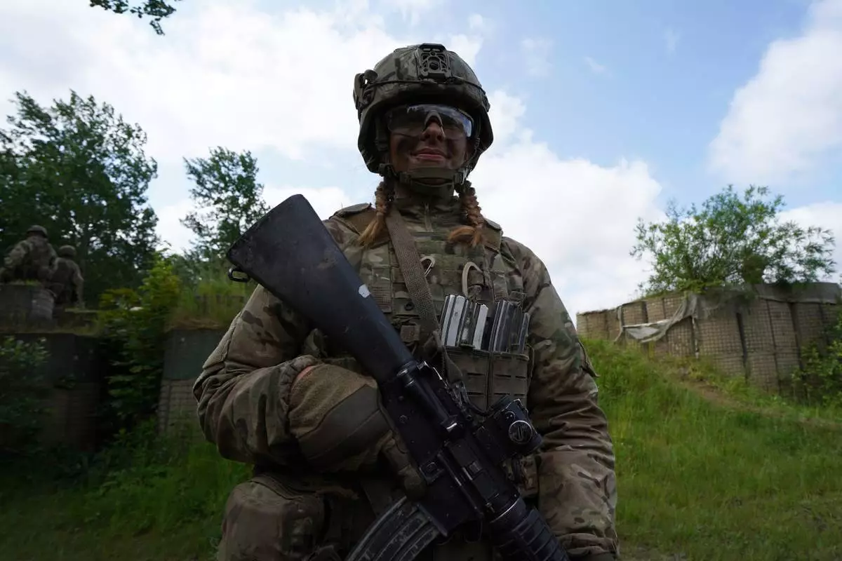 CORRECTS THE NAME OF PERSON'S ROLE - 20-year-old Katrine poses for a photo during final exercises at a training area close to Royal Danish Army’s barracks in Hovelte, 25 kilometres north of Copenhagen, Denmark, Wednesday, June 11, 2025. (AP Photo/James Brooks)