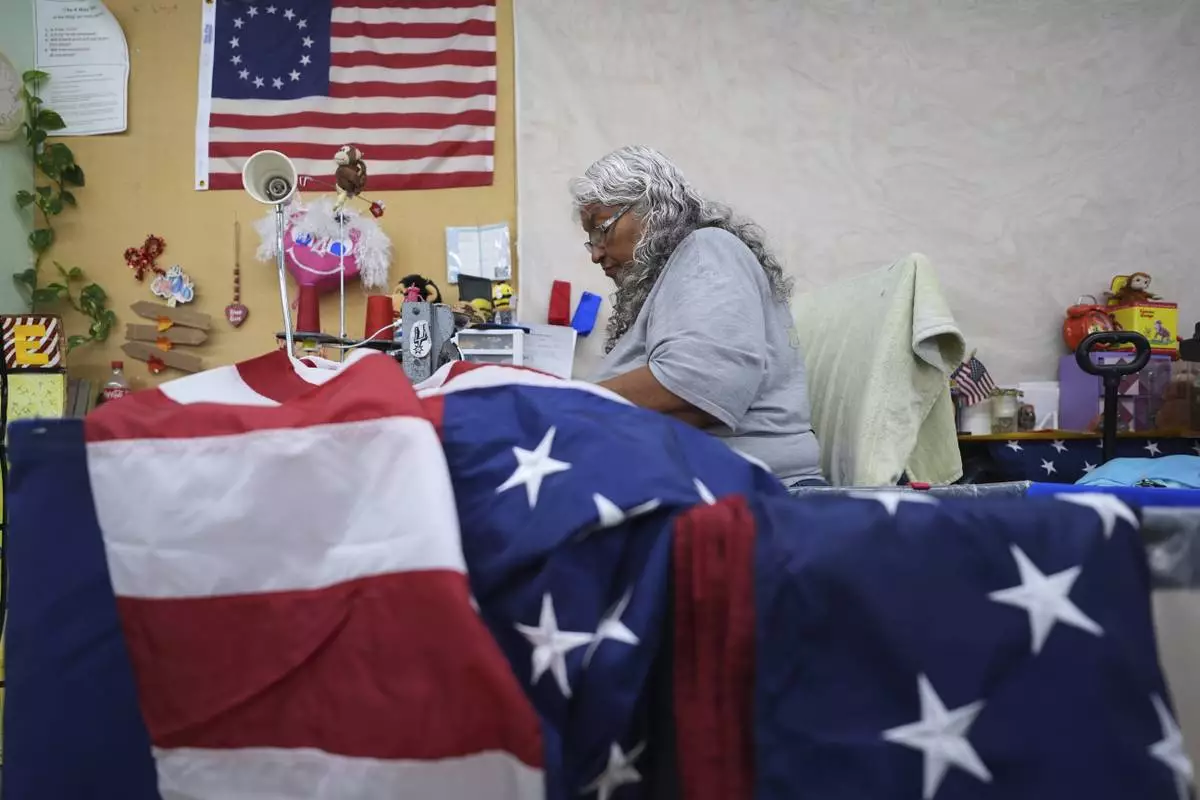 Gloria Ramos sews reinforcement into U.S. flags at Dixie Flag and Banner, Tuesday, June 10, 2025, in San Antonio. (AP Photo/Eric Gay)