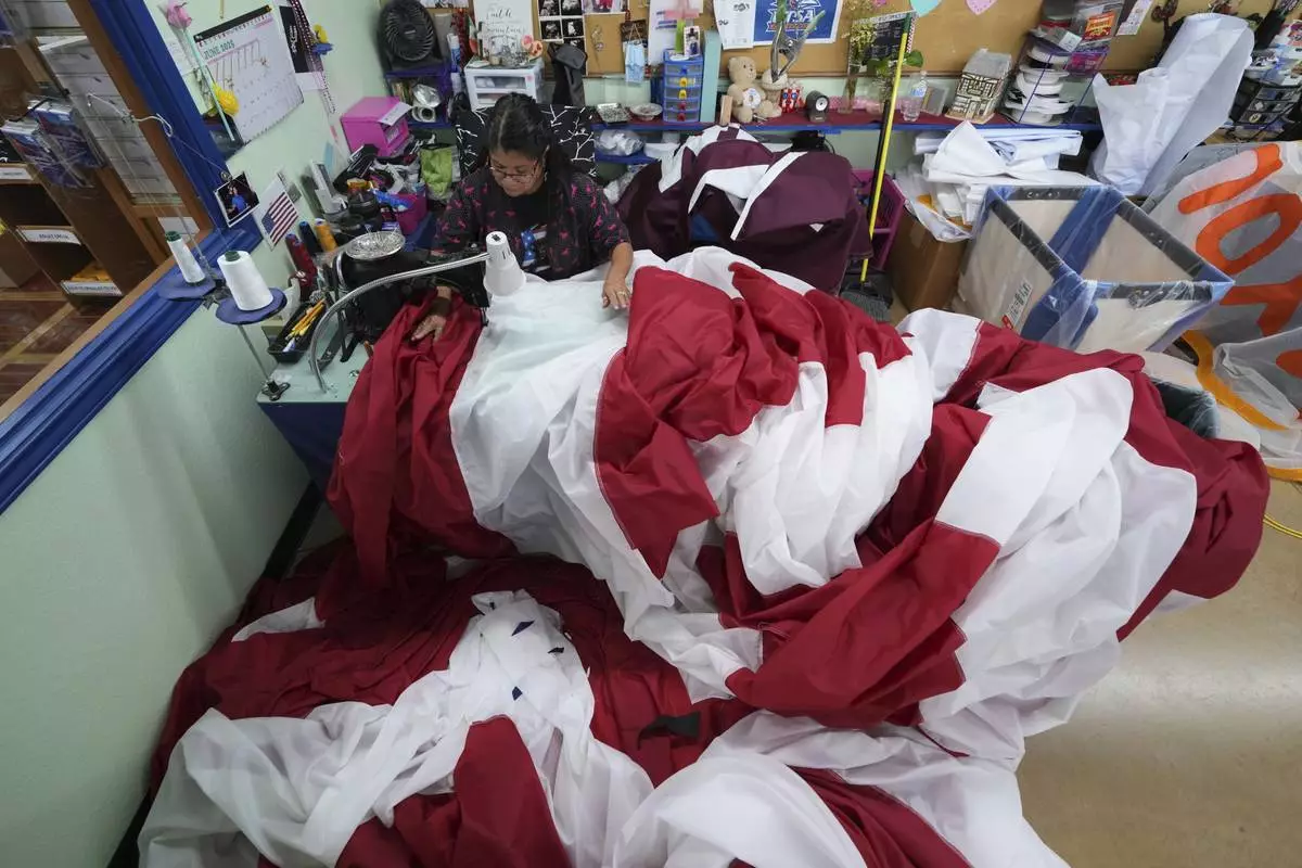 Lucy A. Rodriguez sews the stripes for a large U.S. flag at Dixie Flag and Banner, Tuesday, June 10, 2025, in San Antonio. (AP Photo/Eric Gay)