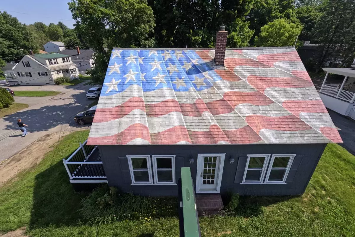 A painting of an American flag decorates the roof of a financial services business, Wednesday, June 11, 2025, in Lewiston, Maine. (AP Photo/Robert F. Bukaty)