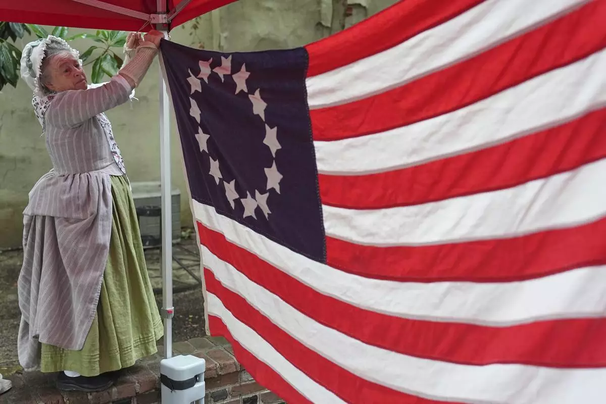 Cornelia Bridges secures a flag for an education program at the Betsy Ross House in Philadelphia, Monday, June 9, 2025. (AP Photo/Matt Rourke)
