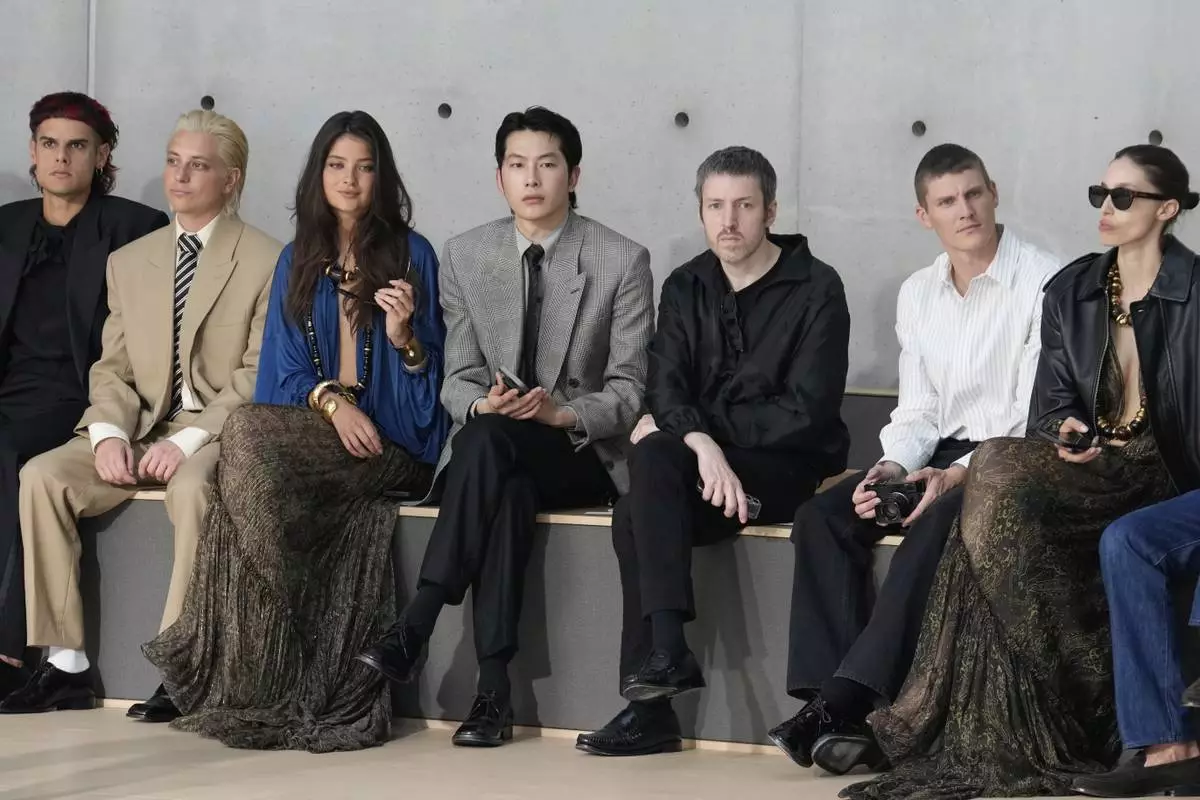 Zel, center, attends the men's Saint Laurent Spring-Summer 2026 collection, that was presented in Paris, Tuesday, June 24, 2025. (AP Photo/Michel Euler)