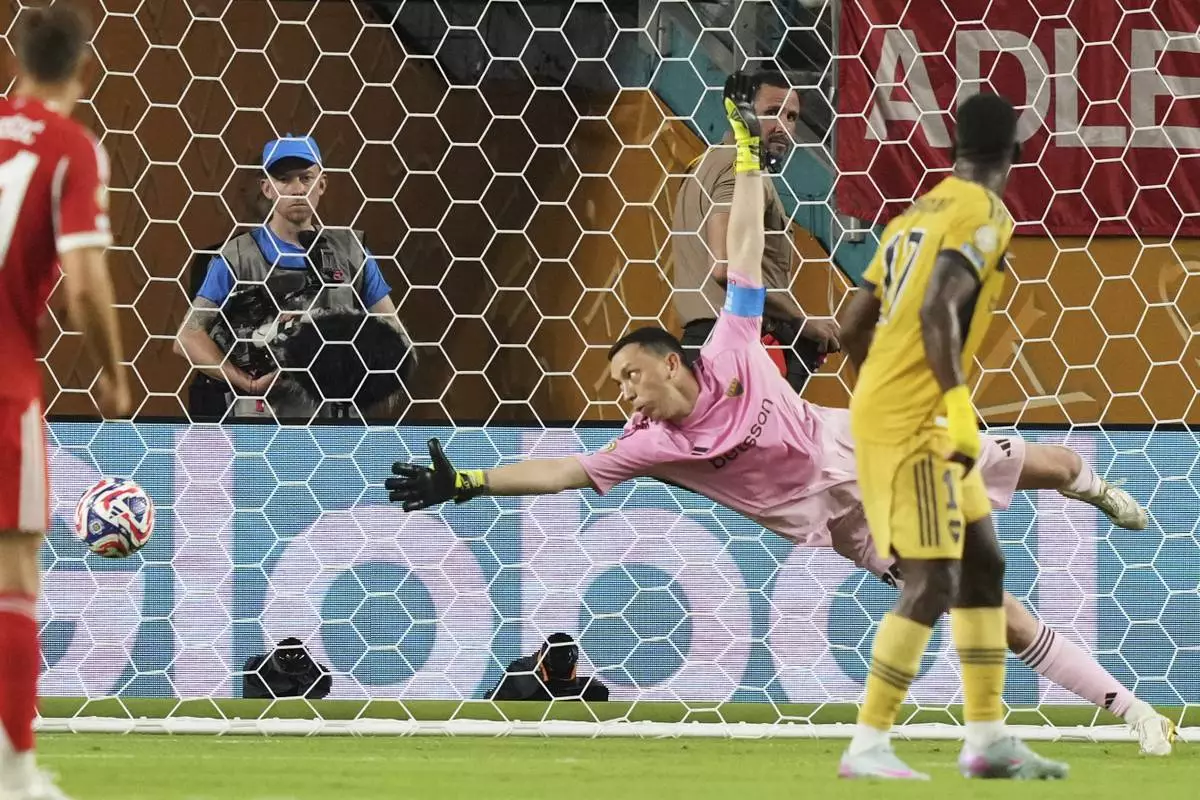 Boca Juniors' goalkeeper Agustin Marchesin dives as he fails to stop a goal by Bayern Munich's Michael Olise (not shown) during the Club World Cup Group C soccer match between Bayern Munich and Boca Juniors in Miami Gardens, Fla., Friday, June 20, 2025. (AP Photo/Lynne Sladky)