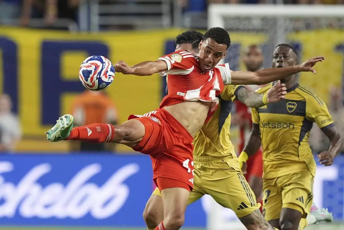 Bayern Munich's Jamal Musiala, front, is challenged by Boca Juniors' Lautaro Di Lollo, back, during the Club World Cup Group C soccer match between Bayern Munich and Boca Juniors in Miami Gardens, Fla., Friday, June 20, 2025. (AP Photo/Rebecca Blackwell)