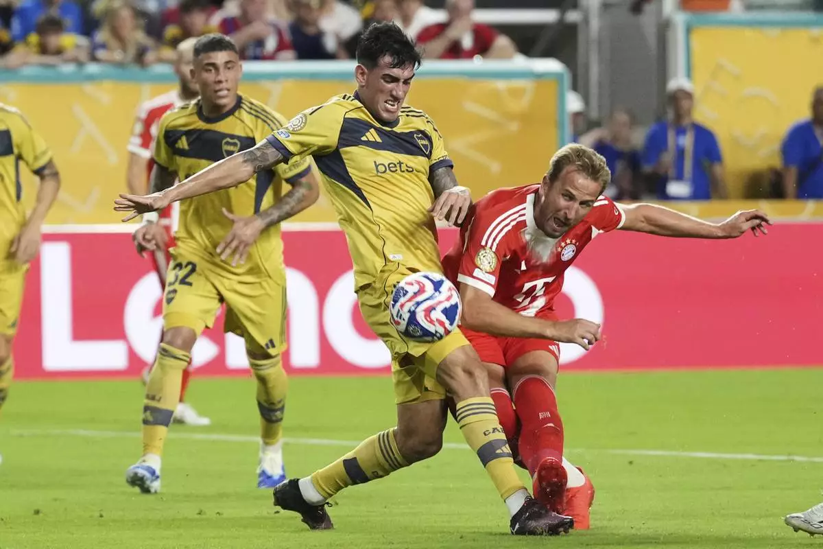 Bayern Munich's Harry Kane, right, attempts a shot on goal challenged by Boca Juniors' Lautaro Di Lollo during the Club World Cup Group C soccer match between Bayern Munich and Boca Juniors in Miami Gardens, Fla., Friday, June 20, 2025. (AP Photo/Rebecca Blackwell)