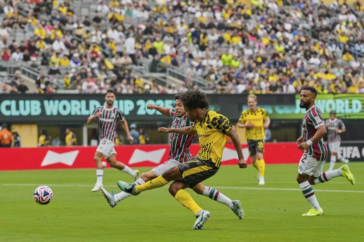 Borussia Dortmund's Karim Adeyemi, front, shoots at goal as Fluminense's Nonato (16) defends during the Club World Cup group F soccer match between Fluminense and Borussia Dortmund in East Rutherford, N.J., Tuesday, June 17, 2025. (AP Photo/Seth Wenig)