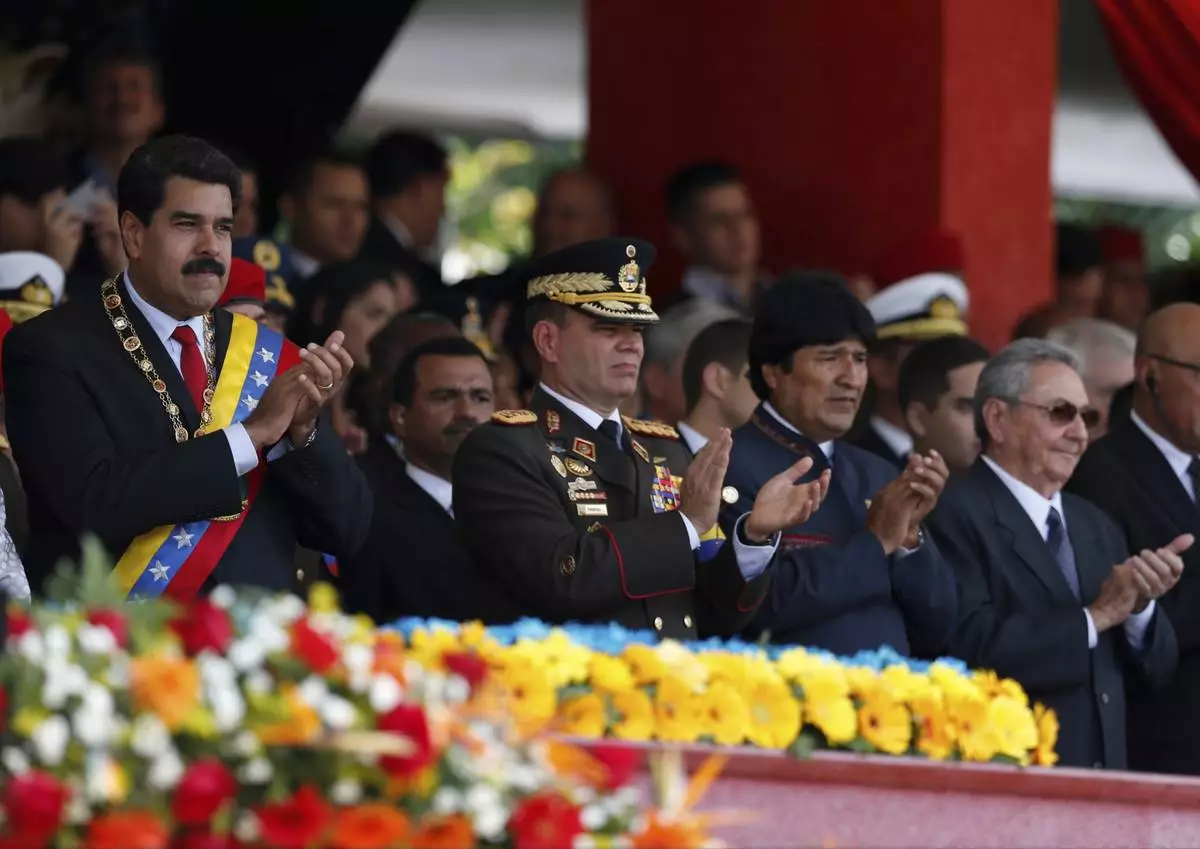 FILE - Venezuela's President Nicolas Maduro, from left, Operational Strategic Commander Gen. Vladimir Padrino Lopez, Bolivia's President Evo Morales and Cuba's President Raul Castro applaud during a military parade commemorating the one year anniversary of the death of Venezuela's former President Hugo Chavez in Caracas, Venezuela, March 5, 2014. (AP Photo/Fernando Llano, File)