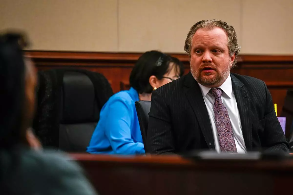 James Craig talks with his family from his seat before opening arguments in his murder trial, as he is accused of killing his wife, at the Arapahoe District Court, Tuesday, July 15, 2025, in Centennial, Colo. (Stephen Swofford via Denver Gazette, Pool)