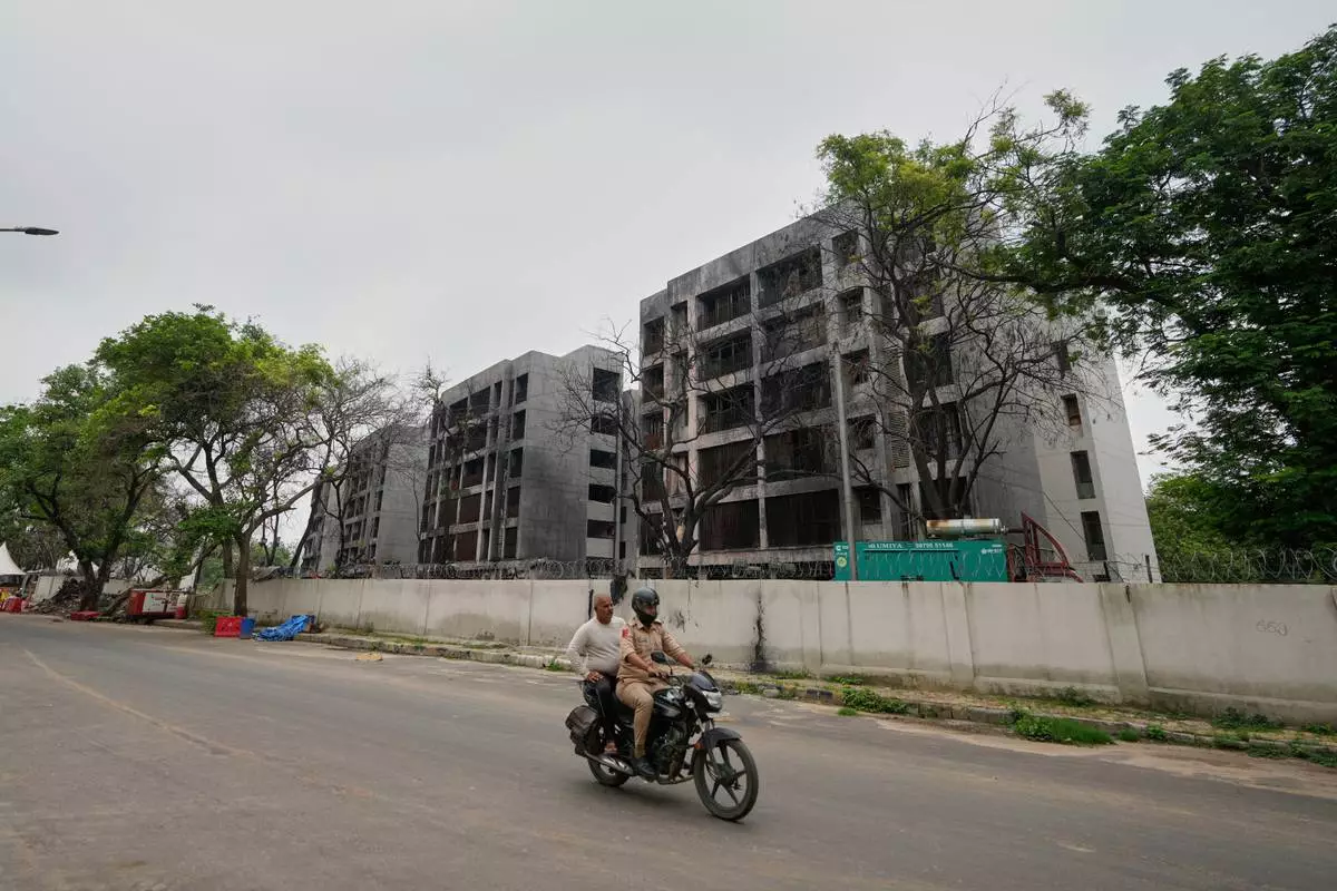 Policemen ride past buildings damaged in the June 12 Air India plane crash in Ahmedabad, India, Saturday, July 12, 2025. (AP Photo/Ajit Solanki)