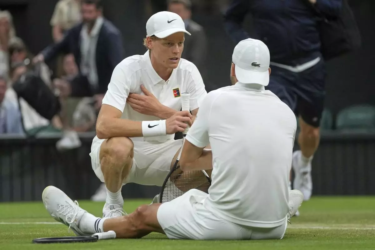 Italy's Jannik Sinner checks on Bulgaria's Grigor Dimitrov after he went down with an injury during a fourth round men's singles match at the Wimbledon Tennis Championships in London, Monday, July 7, 2025. (AP Photo/Kin Cheung)