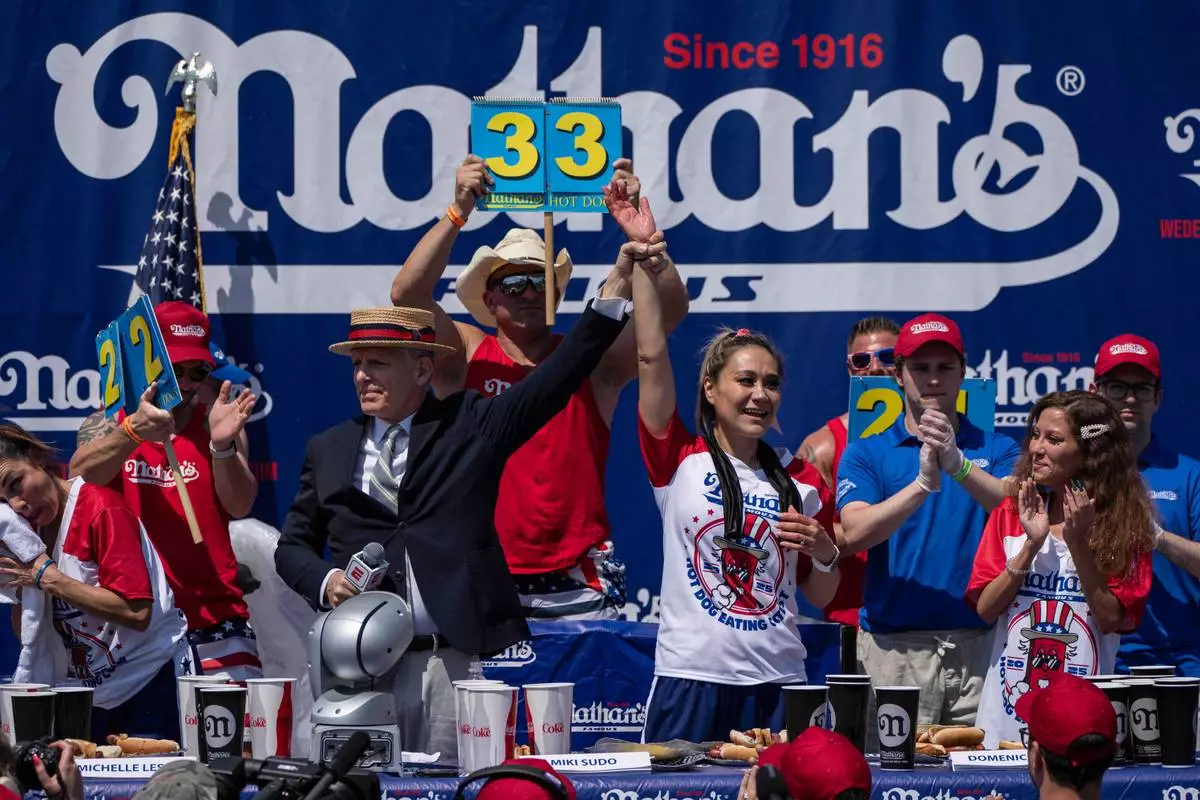Competitive eater Miki Sudo, center, celebrates after finishing 1st during the 2025 Nathan's Famous Fourth of July hot dog eating contest in the Coney Island section of the Brooklyn borough of New York, Thursday, July 4, 2025. (AP Photo/Yuki Iwamura)