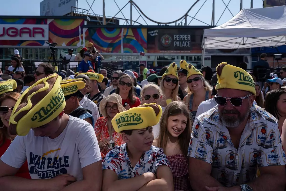 People wait for the 2025 Nathan's Famous Fourth of July hot dog eating contest in the Coney Island section of the Brooklyn borough of New York, Thursday, July 4, 2025. (AP Photo/Yuki Iwamura)