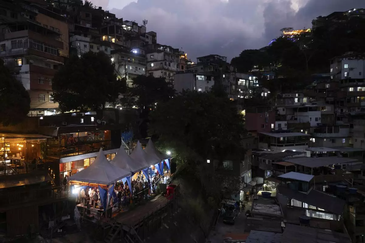 People attend a performance by American vocalist of Hindu devotional music Jeff Kagel during a Tranformation Project yoga class in the Rocinha favela, Rio de Janeiro, Wednesday, July 9, 2025. (AP Photo/Bruna Prado)