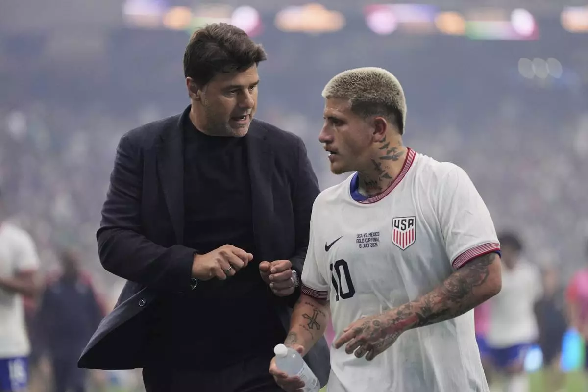 United States head coach Mauricio Pochettino, left, talks with midfielder Diego Luna (10) as they walk off the field at halftime of the team's CONCACAF Gold Cup final soccer match against Mexico in Houston, Sunday, July 6, 2025. (AP Photo/Ashley Landis)