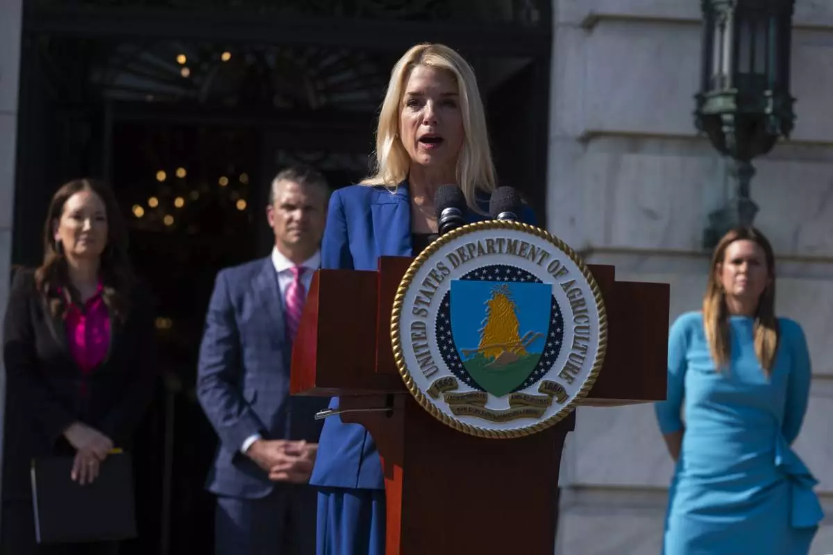 Attorney General Pam Bondi, front, with Agriculture Secretary Brooke Rollins, back left to right, Secretary of Defense Pete Hegseth and Arkansas Gov. Sarah Huckabee Sanders, speaks during a news conference at the Department of Agriculture to rollout the USDA'S National Farm Security Action Plan and discuss actions being taken to protect American agriculture from foreign threats in Washington, Tuesday, July 8, 2025. (AP Photo/Manuel Balce Ceneta)