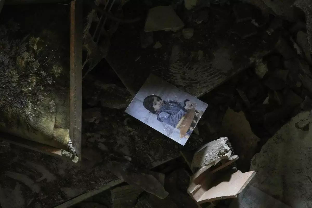 A photo of a child is seen amid the rubble of a destroyed building following an Israeli strike, in Tehran, Iran, Wednesday, June 25, 2025. (AP Photo/Vahid Salemi)