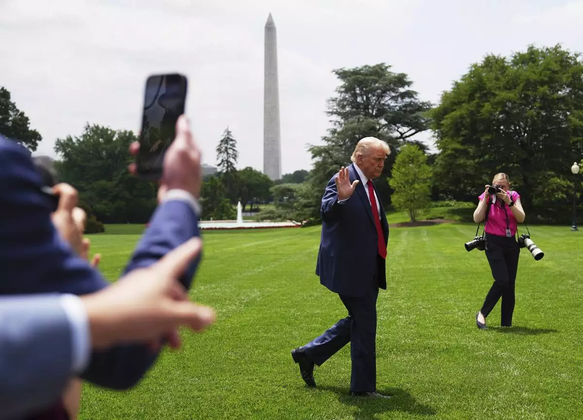 President Donald Trump arrives on the South Lawn of the White House, Monday, June 9, 2025, in Washington. The Washington Monument is seen in background. (AP Photo/Evan Vucci)