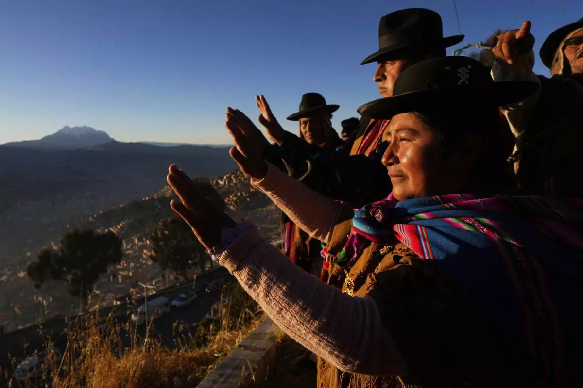 Aymara Indigenous people hold up their hands to receive the first rays of sunlight in celebration of the Andean New Year 5533 marking the Southern Hemisphere's winter solstice, in El Alto, Bolivia, Saturday, June 21, 2025. (AP Photo/Juan Karita)
