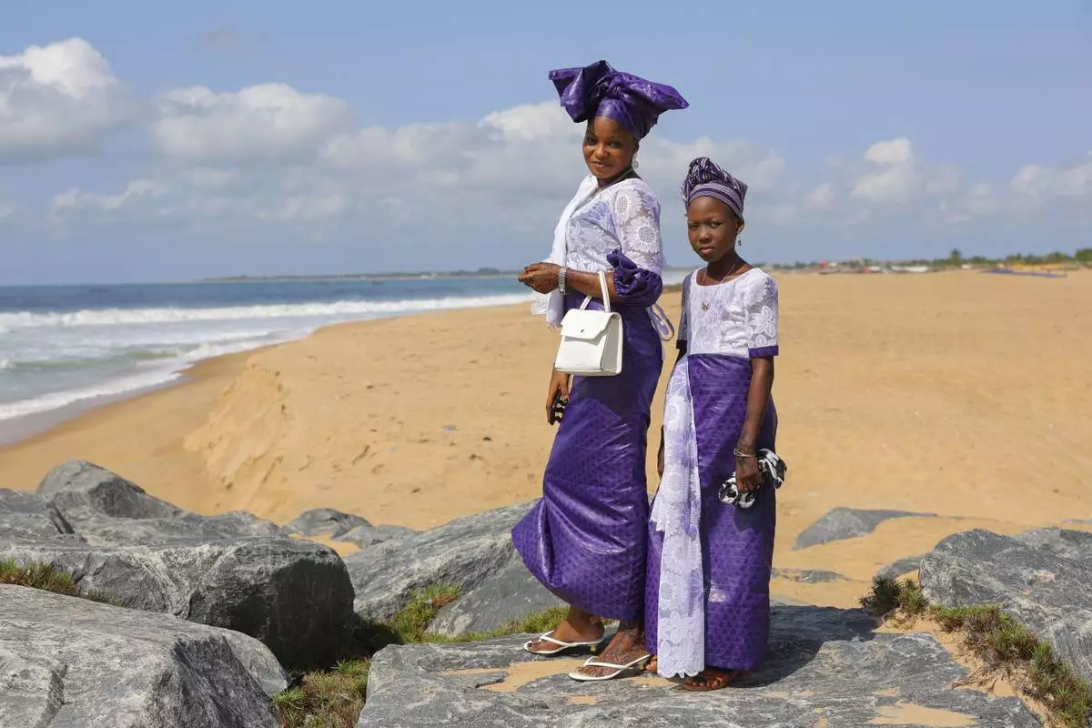 A mother and daughter pose for a photo at a beach after Eid al-Adha prayers in Keta, Ghana, Friday, June 6, 2025. (AP Photo/Misper Apawu)